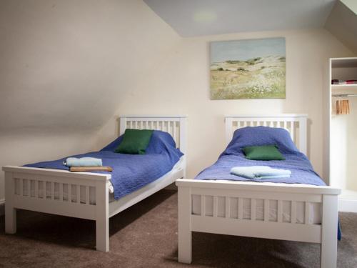 two beds sitting next to each other in a bedroom at The Grooms Cottage in Mauchline