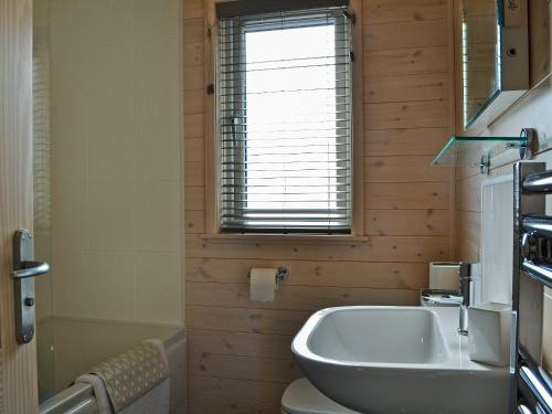 a bathroom with a sink and a toilet and a window at Bransty in Keswick