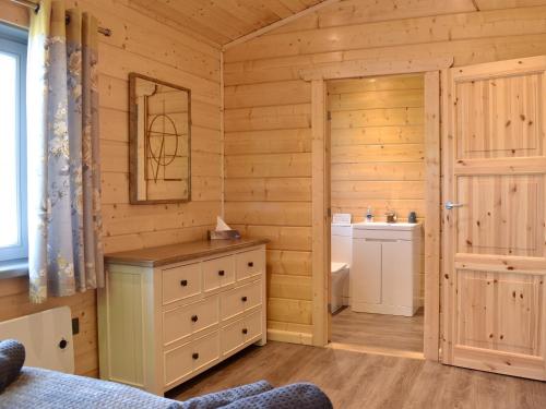 Birch Lodge - Uk30006 في Lindal in Furness: حمام كابينة خشب مع حوض ومرحاض