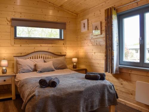 a bedroom with a bed in a log cabin at Birch Lodge - Uk30006 in Lindal in Furness