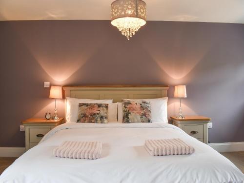um quarto com uma grande cama branca e 2 almofadas em The Cottage At Stainsacre Hall em Hawsker