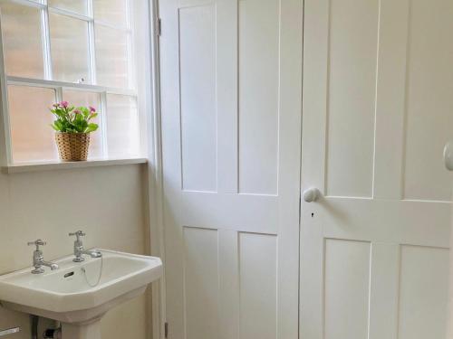 a bathroom with a sink and a white door at Heath View in Cheddleton