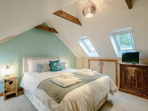 a bedroom with a bed with two towels on it at Farriers Lodge in Burshill