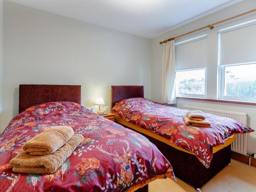 two beds sitting next to each other in a bedroom at Cairn-o-mhor in Lendalfoot