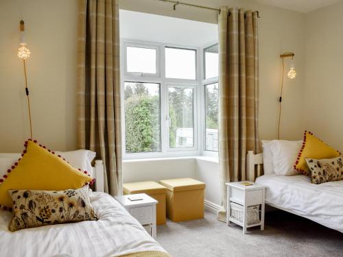 Knitsley的住宿－Manor Park Cottage，一间卧室设有两张床和窗户。
