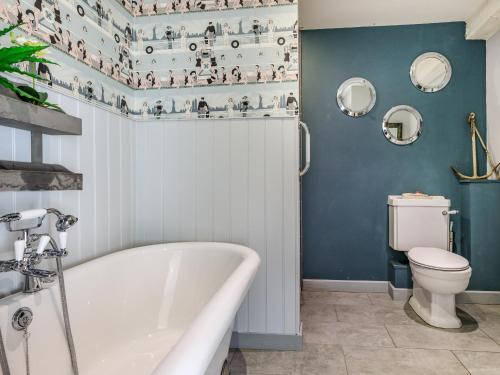 a bathroom with a tub and a toilet at The Cider Barn in Buckland St Mary