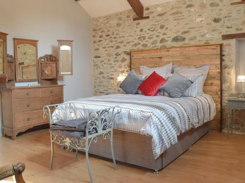 a bedroom with a bed with a wooden headboard at Tynval in Carmarthen