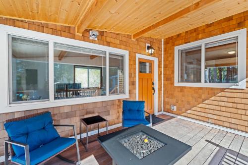 a patio with two chairs and a table and windows at Relajate y recargate de buena vibra en nuestras cabanas de Camano Island in Camano