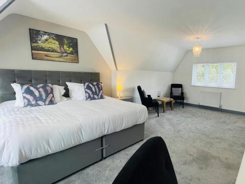 a bedroom with a large white bed and a desk at Warren Lodge in Little Baddow