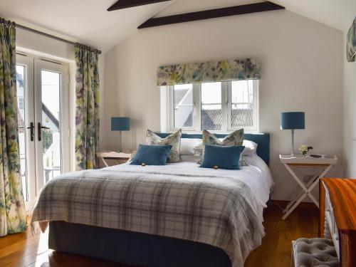 a bedroom with a large bed with blue pillows at The Boathouse Uk33900 in Waldringfield