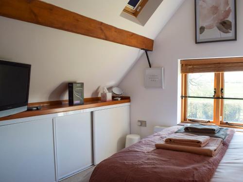 a bedroom with a bed with a tv and a window at Twin Oaks in Crudgington