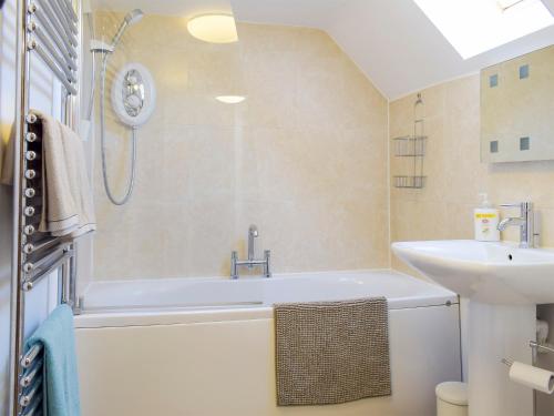 a bathroom with a bath tub and a sink at Twin Oaks in Crudgington