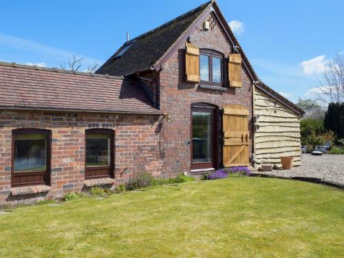 a brick house with a lawn in front of it at Twin Oaks in Crudgington