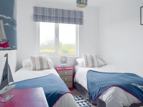 a bedroom with two beds and a window at Cheviot View in Beal