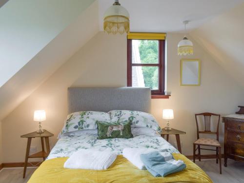 1 dormitorio con 1 cama con toallas en Cluniter Cottage, en Innellan
