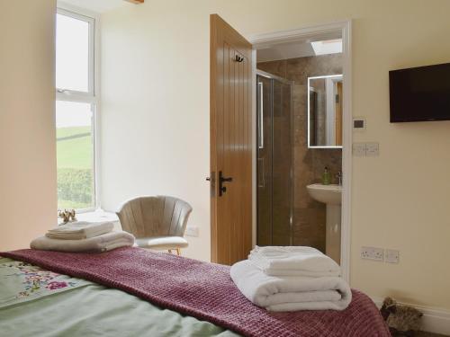 a bedroom with a bed with towels on it at Tormire Laithe in Bell Busk