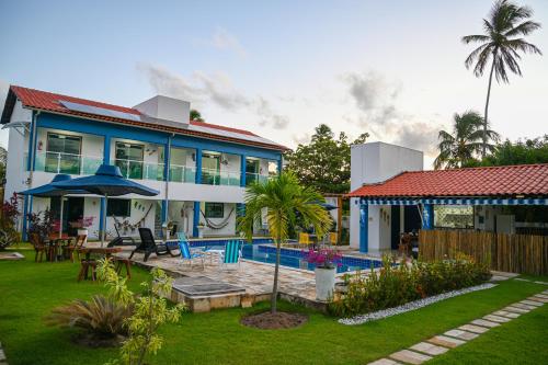 a house with a yard with a swimming pool at Chalés Casuarinas in Japaratinga