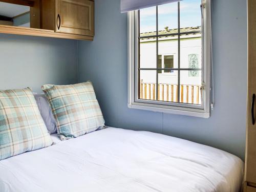 a bedroom with a bed and a window at Sunnyside Lodge in Monreith