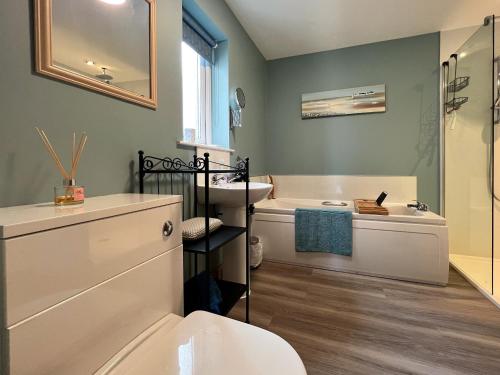 a bathroom with a tub and a sink and a toilet at Hirta Cottage in Staffin