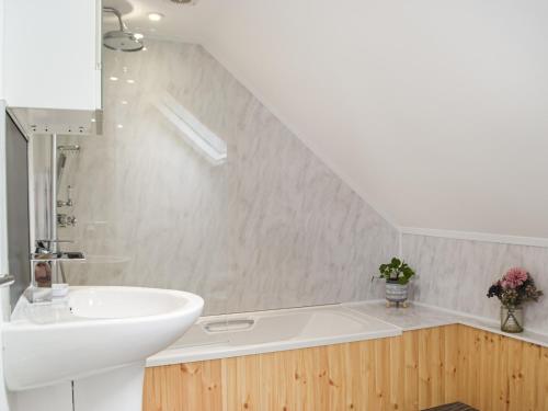 a bathroom with a sink and a bath tub at Pinch Cottage in Neyland