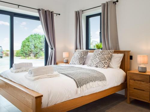 1 dormitorio con cama y ventana grande en Hafan Gwyn en Verwick