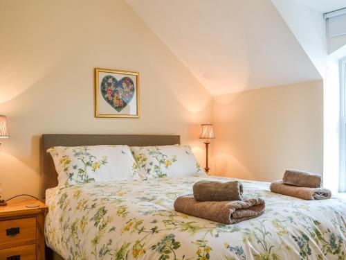 a bedroom with a bed with two towels on it at School Cottage in Lowthorpe