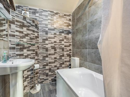 a bathroom with a sink and a bath tub and a toilet at The Hay Loft in Poulton le Fylde