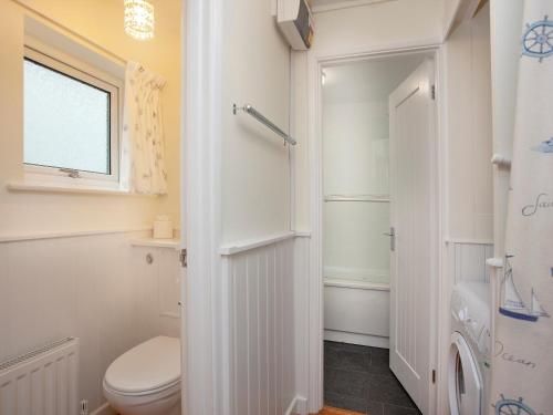 a white bathroom with a toilet and a shower at Devon Court 2 in Salcombe