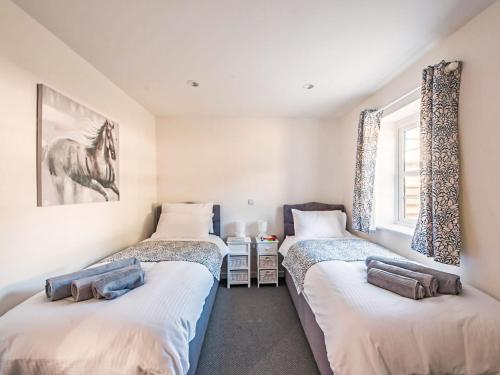 a bedroom with three beds and a window at Willow Cottage - Uk38484 in Saltash