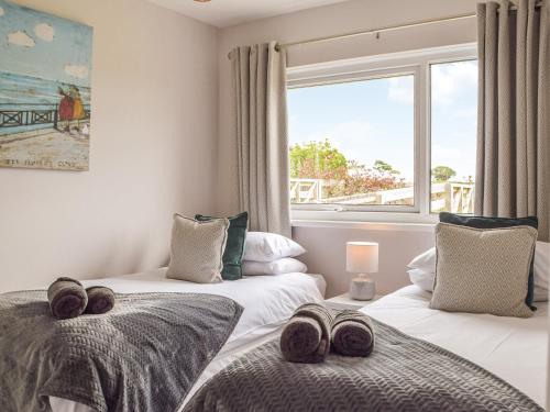 two twin beds in a room with a window at Rowan Cottage in Walton West