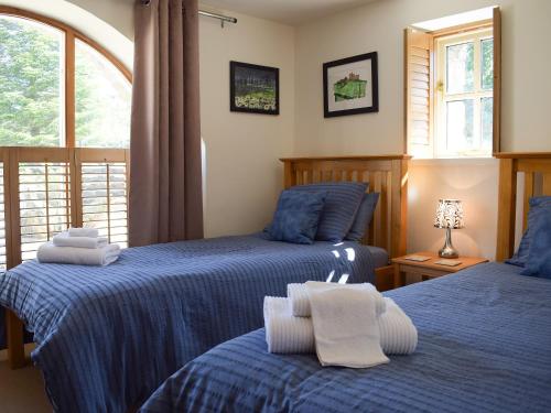a bedroom with two beds and a window at Barn Cottage in Talley