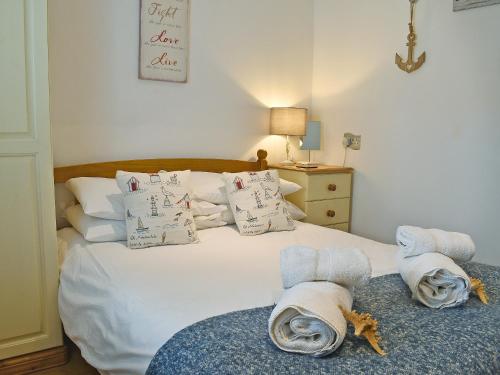 a bedroom with a white bed with towels on it at Trenpeskador - Uk39442 in Saint Columb Minor