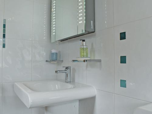 a white bathroom with a sink and a mirror at Trenpeskador - Uk39442 in Saint Columb Minor