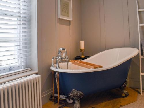 a blue bath tub in a bathroom with a radiator at Garden Flat in Ryde