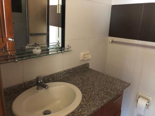La salle de bains est pourvue d'un lavabo et d'un miroir. dans l'établissement Familiar y acogedor, à La Paz
