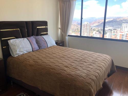 - une chambre avec un lit et une grande fenêtre dans l'établissement Familiar y acogedor, à La Paz
