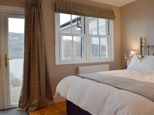 a bedroom with a bed and a large window at Chapelburn in Lawers