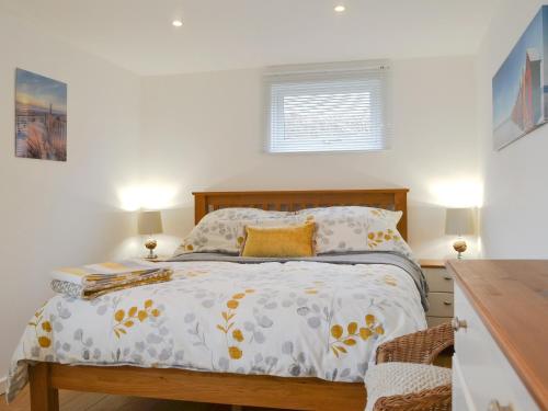 a bedroom with a bed and a window at Stepping Stones in Trearddur