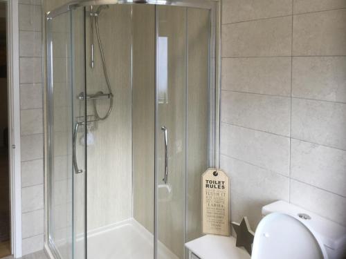 a shower stall in a bathroom with a toilet at Stepping Stones in Trearddur
