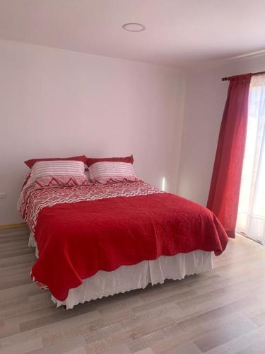 a bedroom with a bed with a red blanket at Loreto y Rodillo in Caldera