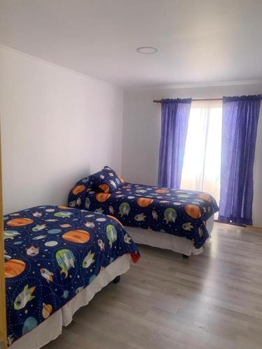 a bedroom with two beds and a window at Loreto y Rodillo in Caldera