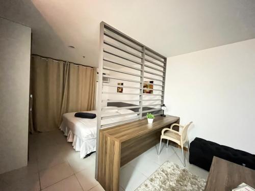 um quarto com 2 camas, uma secretária e uma mesa em Flat moderno com piscina e academia em Itaboraí