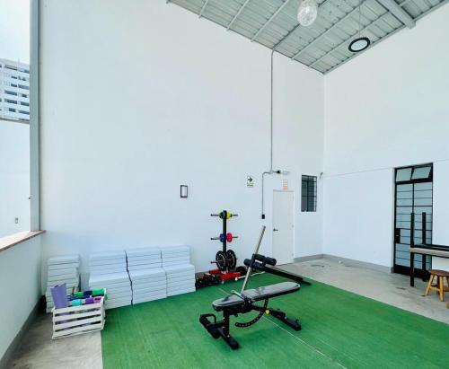 Zimmer mit einem Fitnessraum mit Laufband und grünem Teppich in der Unterkunft Idea Home in Lima