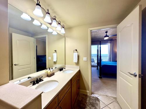a bathroom with two sinks and a large mirror at Lovely 22 In Sienna Overlooking The Gulf in Gulfport