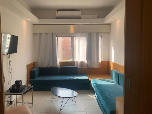 a living room with a blue couch and a table at Real Apartments 255 - High level Copacabana 2 bedrooms close to Ipanema in Rio de Janeiro