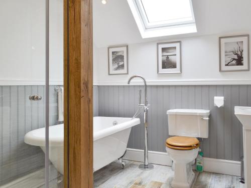 a bathroom with a tub and a toilet and a sink at Woodhouse View in Helsby