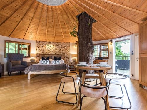 a bedroom with a bed and a table and chairs at Bensfield Treehouse in Wadhurst