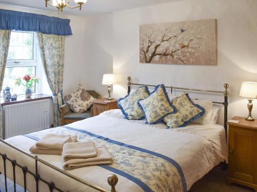 1 dormitorio con 1 cama con almohadas azules y blancas en Bumblebee Nook, en Penrith