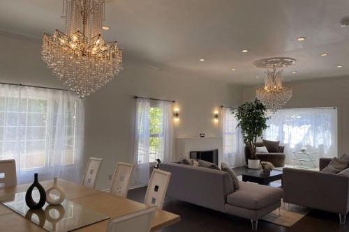 a living room with two chandeliers and a dining room at Stylish Getaway Stay In Beverly Hills in Los Angeles
