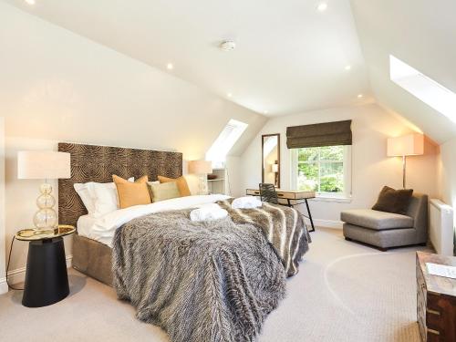 a large bedroom with a large bed and a chair at The Indie House in Crieff
